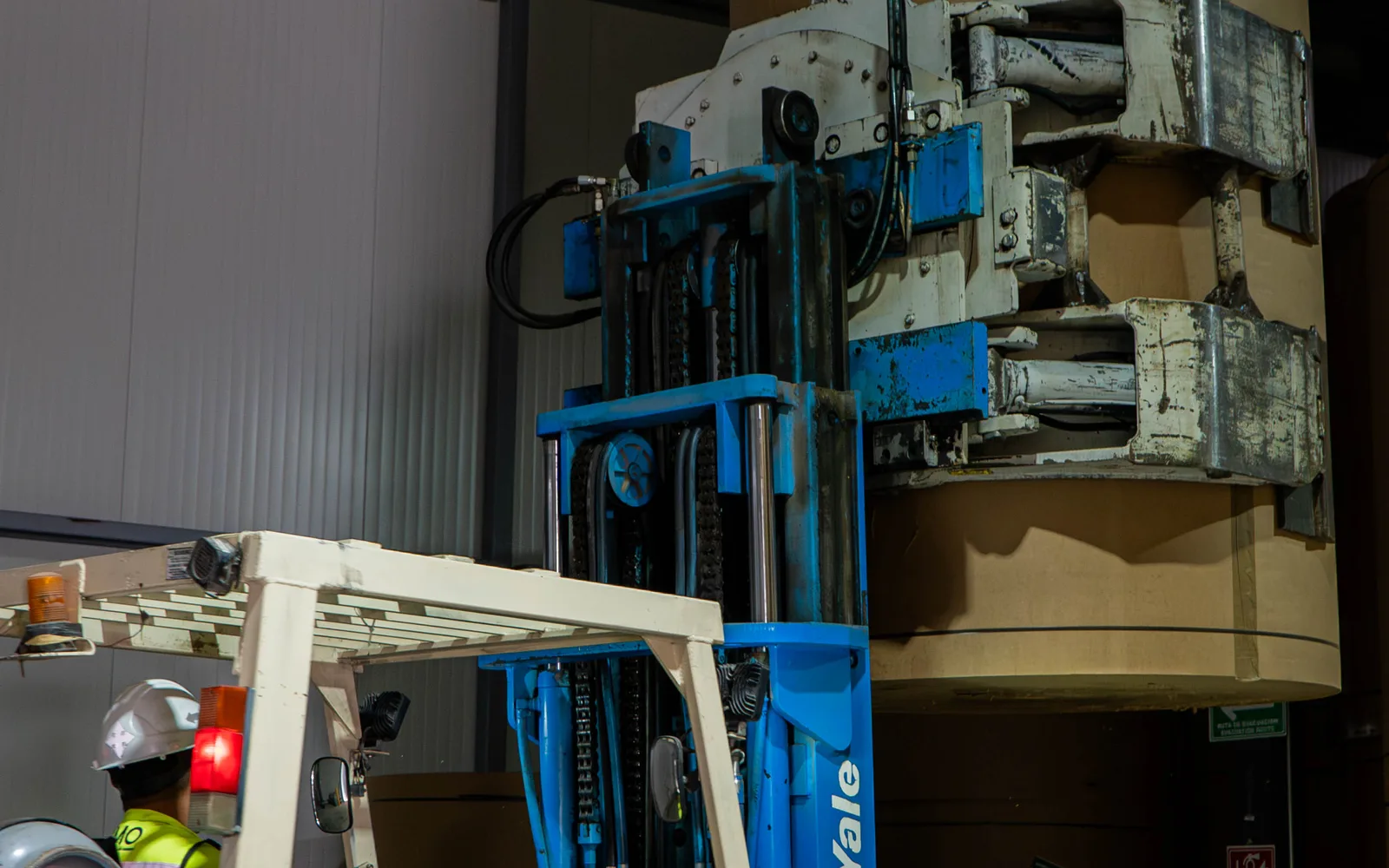 Montacargas clamp sujetando una bobina de papel en la bodega de crossdock